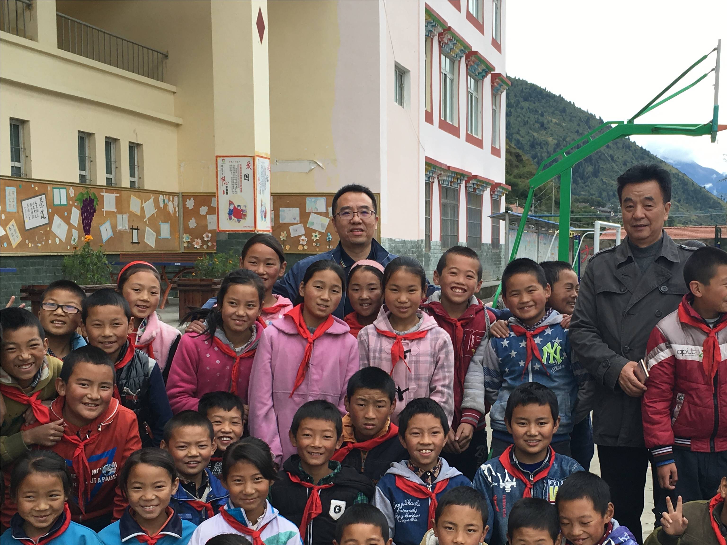 成都乐竞平台_乐竞（中国）集团领导与小金县两河口镇学生合影